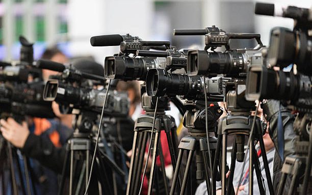 Press cameras lined up at a news conference